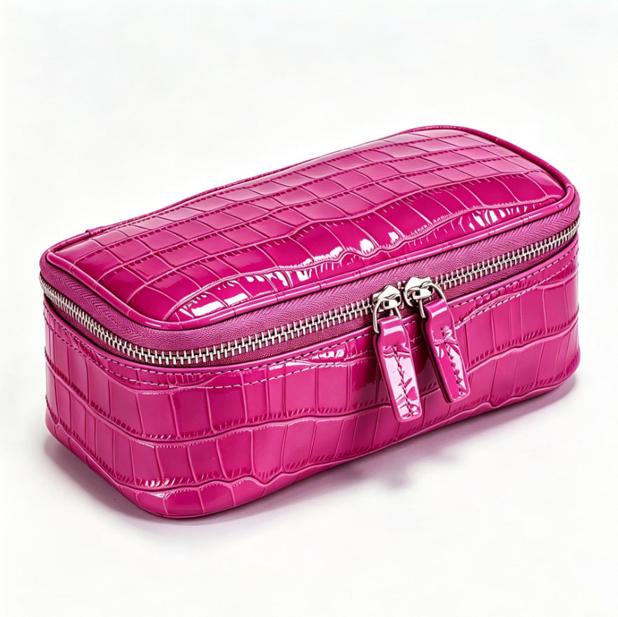 Magenta crocodile pattern genuine leather cosmetic bag with silver double zipper, three quarter view