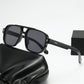 Square double bridge sunglasses with a black frame and gray lenses on a black case