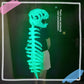 Side view of a glowing green dinosaur skeleton costume with an open jaw skull and spine in the dark