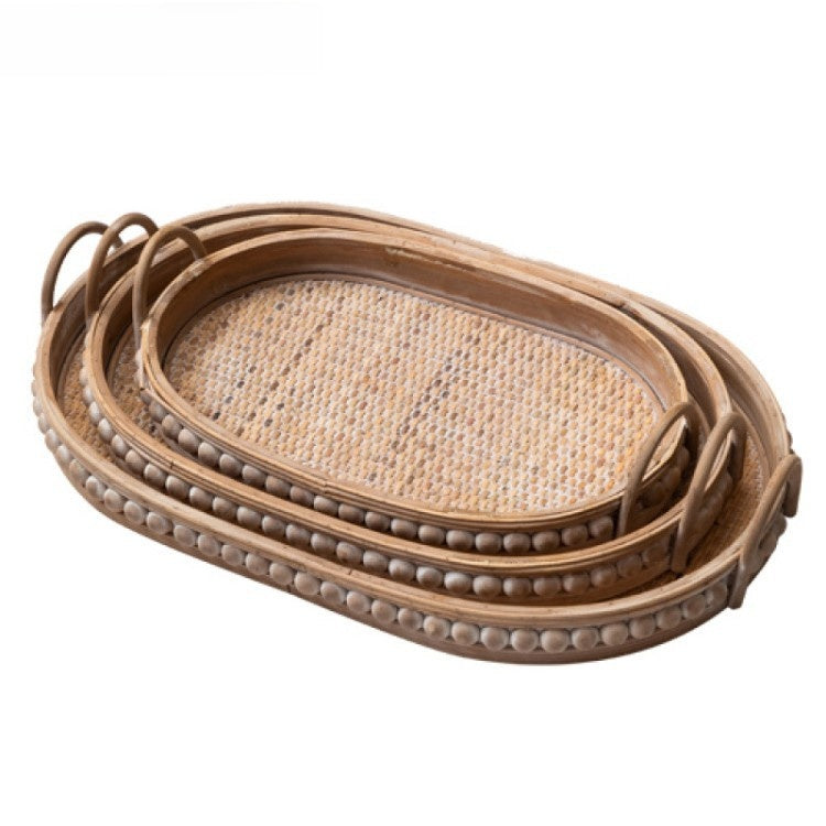 Set of three oval rattan trays nested together with studded wooden rims and arched handles, Three-piece set option