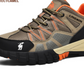 Close up of tan mesh and microfiber shoe with orange laces, camel logo on black toe cap and deep lugged sole
