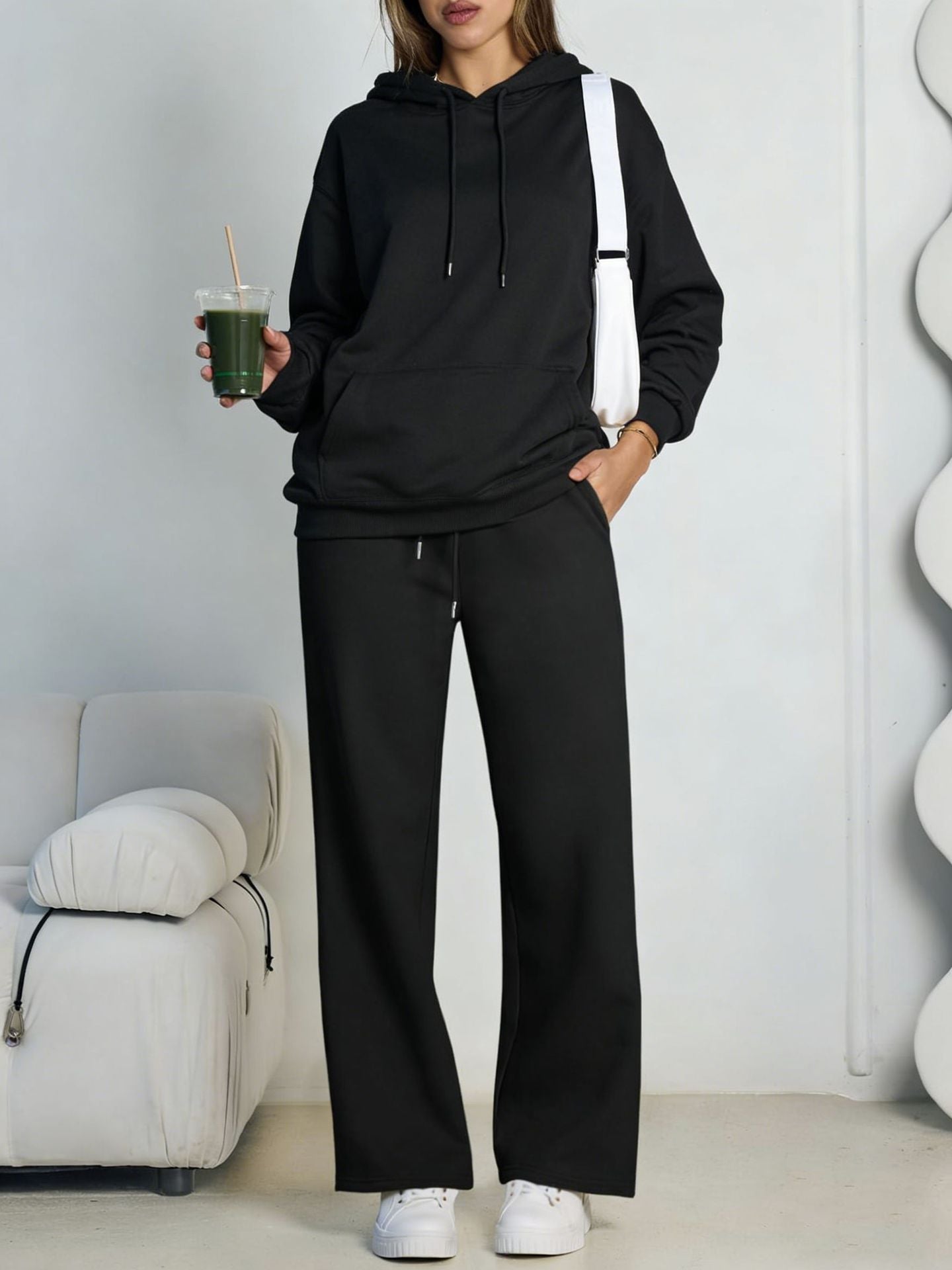 Black fleece hooded sweatshirt and wide-leg sweatpants set worn by a model