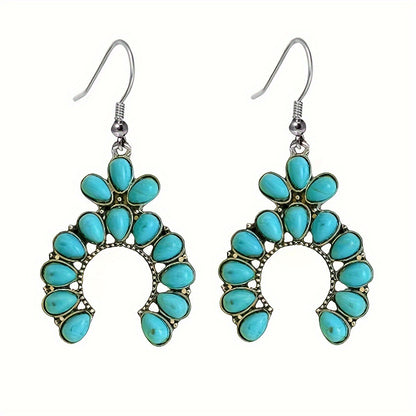 Pair of crescent drop earrings with turquoise colored teardrop stones and fish hook ear wires on a white background
