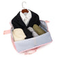Open pink duffel travel bag showing a black blazer, a white shirt and folded clothes inside a light lining