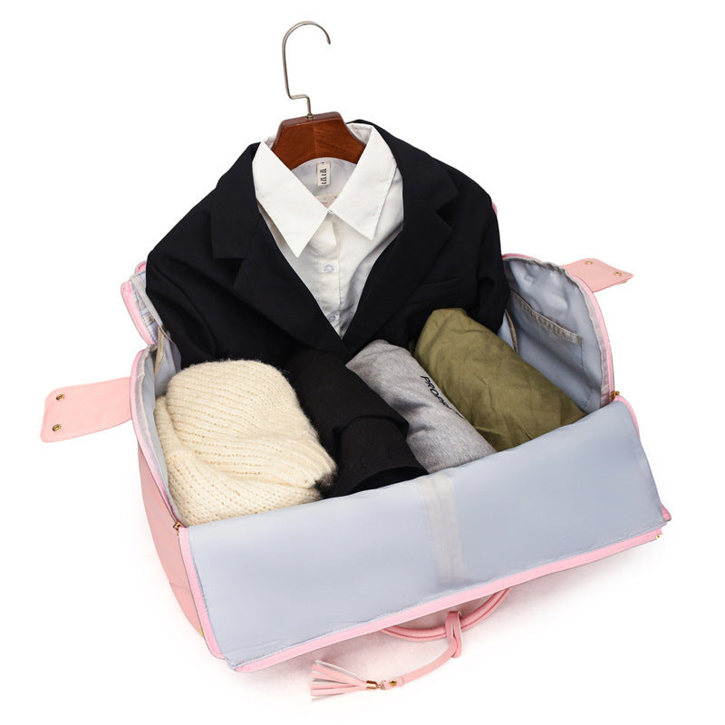 Open pink duffel travel bag showing a black blazer, a white shirt and folded clothes inside a light lining