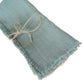 Folded cotton-linen napkin front view showing the raw frayed tassel edge