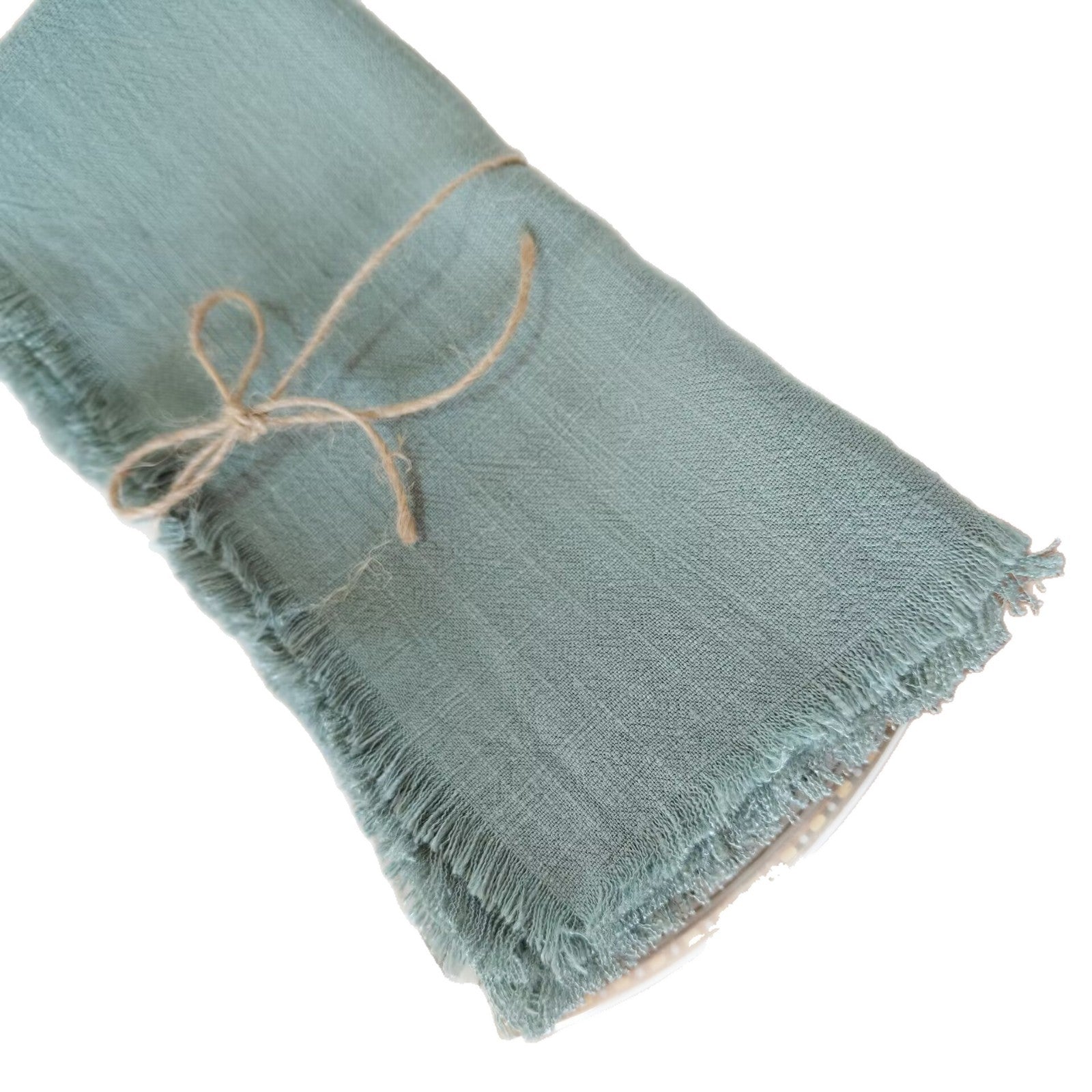 Folded cotton-linen napkin front view showing the raw frayed tassel edge