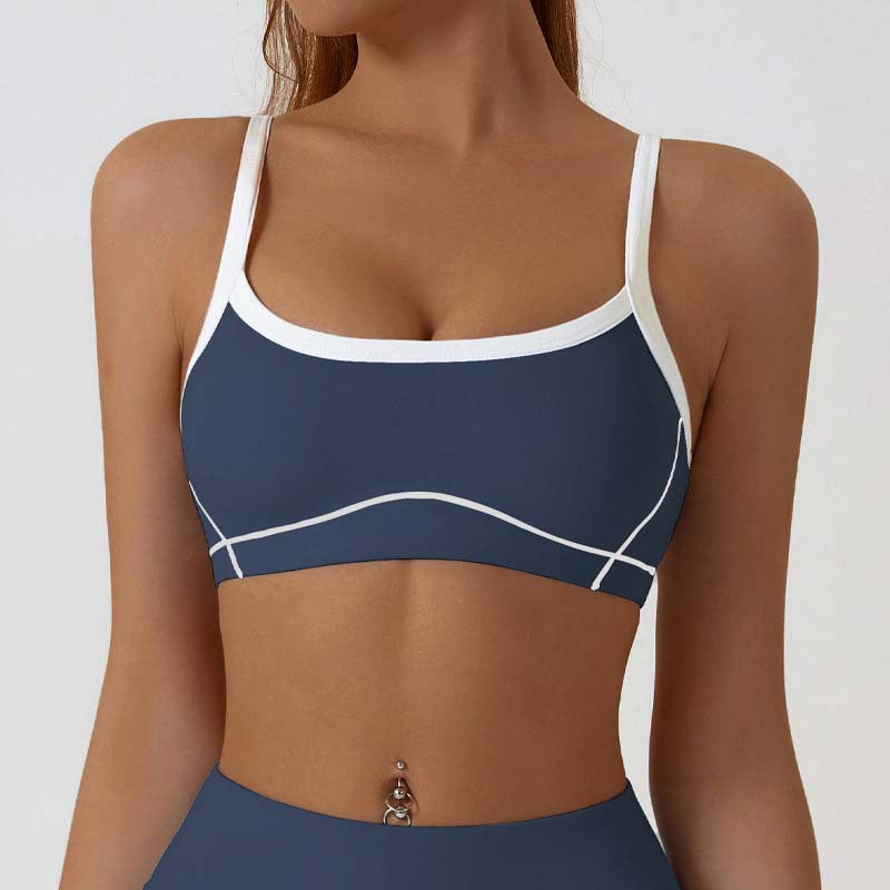 Close view of the contrast piping tracing the bust seams of the strappy sports bra