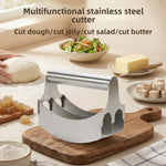 Stainless steel manual cutter on a wood board with dough, salad, butter, and tofu around it