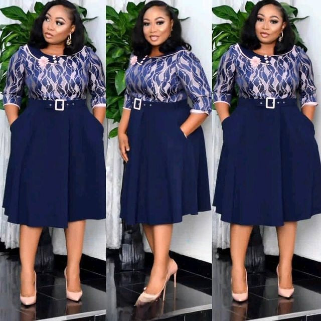 Navy belted midi dress with printed bodice and pleated swing skirt shown on a model