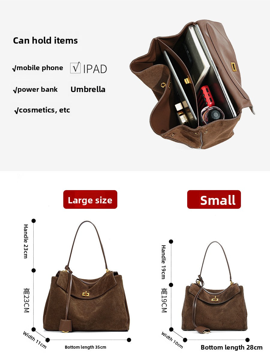 Suede leather tote bag held by the handles showing roomy main compartment
