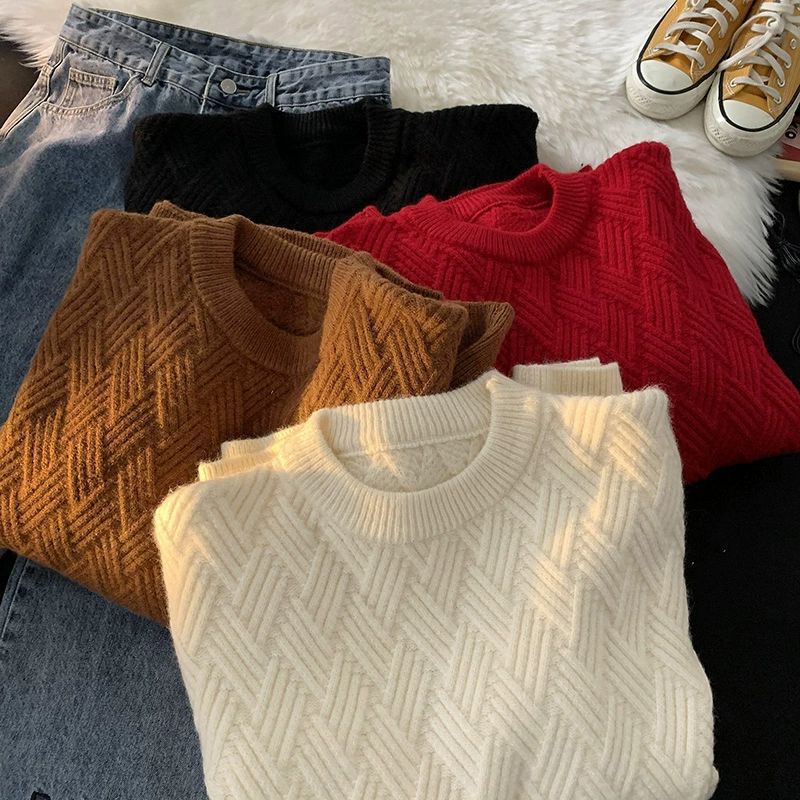 Heavyweight round neck knit pullover with a raised basketweave jacquard texture laid flat