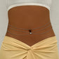 Three row silver tone waist chain with a small heart stone at the centre, worn over a wrap skirt