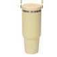 Light yellow insulated tumbler with a stainless steel ring below the flip lid and a handle at the top