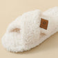 Close up of a Beige crossed plush slipper strap with a brown clover patch