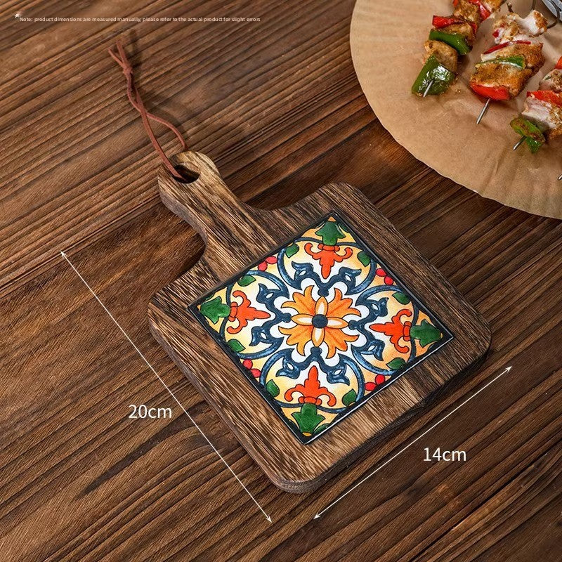 Wood trivet with an orange and blue rosette tile on planks, marked 20 cm by 14 cm