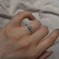 Silver cubic zirconia cluster ring worn on the hand, slim band with a bright round center stone and side accents