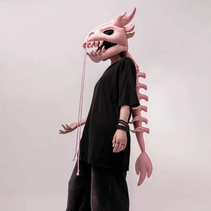 Plush dinosaur skeleton headgear with open jaw teeth and a long padded backbone tail for dress-up