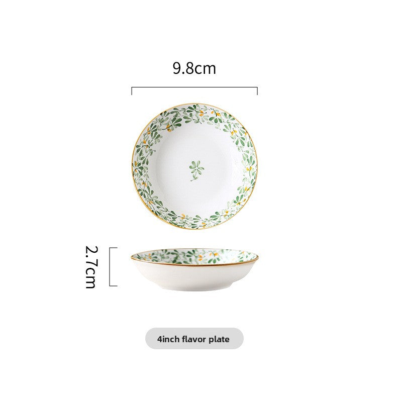 Gold-tone rim detail along a green leaf porcelain bowl edge