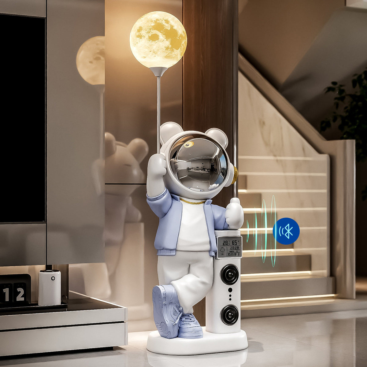 Blue and white astronaut bear statue with moon lamp and Bluetooth symbol beside a staircase