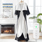 Dark gray wearable electric blanket with foot pockets hanging on a hanger beside a fireplace, UKCA UK 130x180 cm option