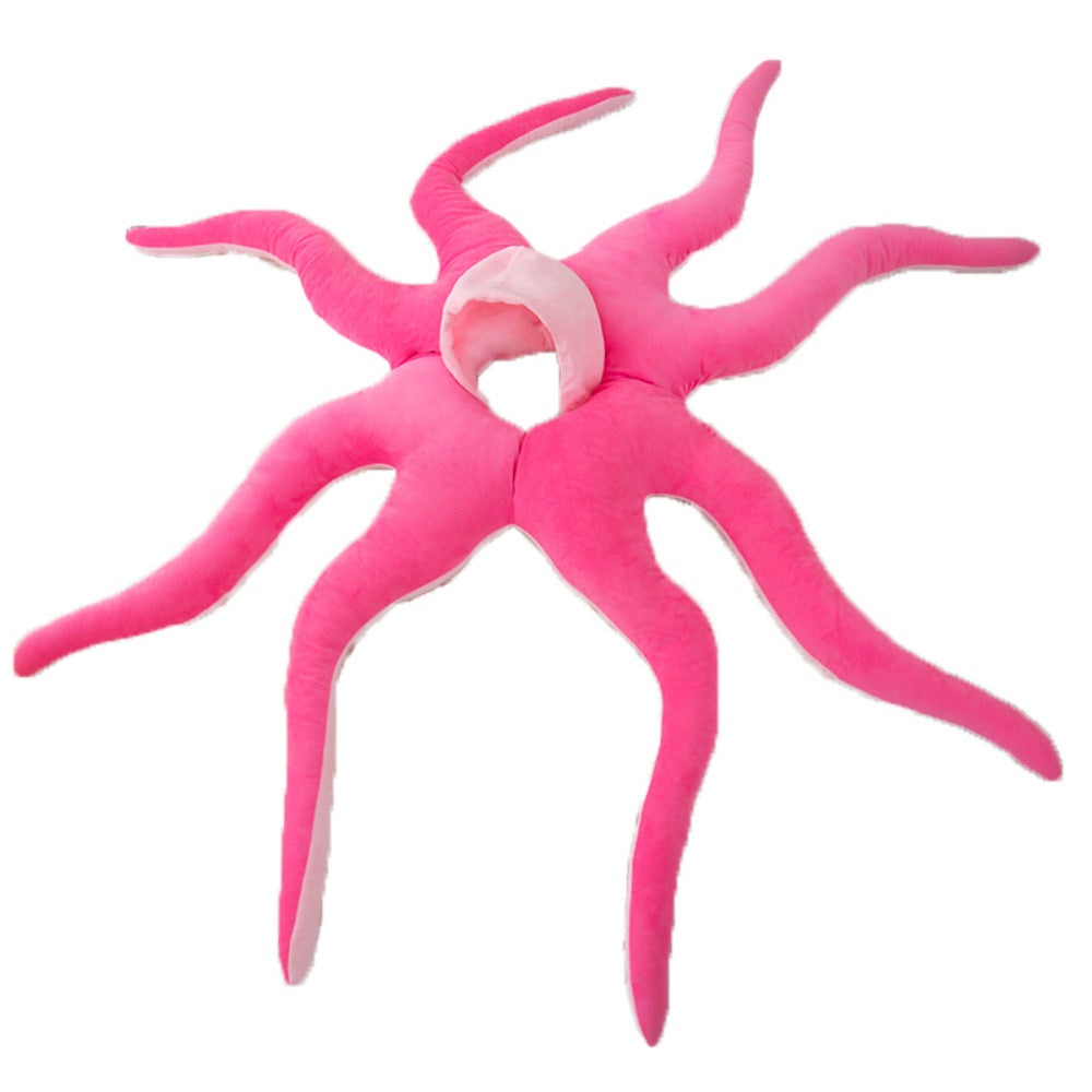 Soft pink octopus costume with tentacles trailing out on a plain background
