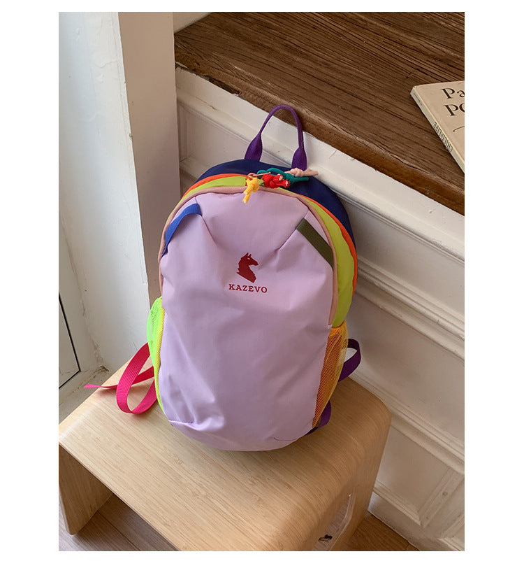 Light purple color block backpack on a wood stool, contrast straps, top handle and rainbow trim