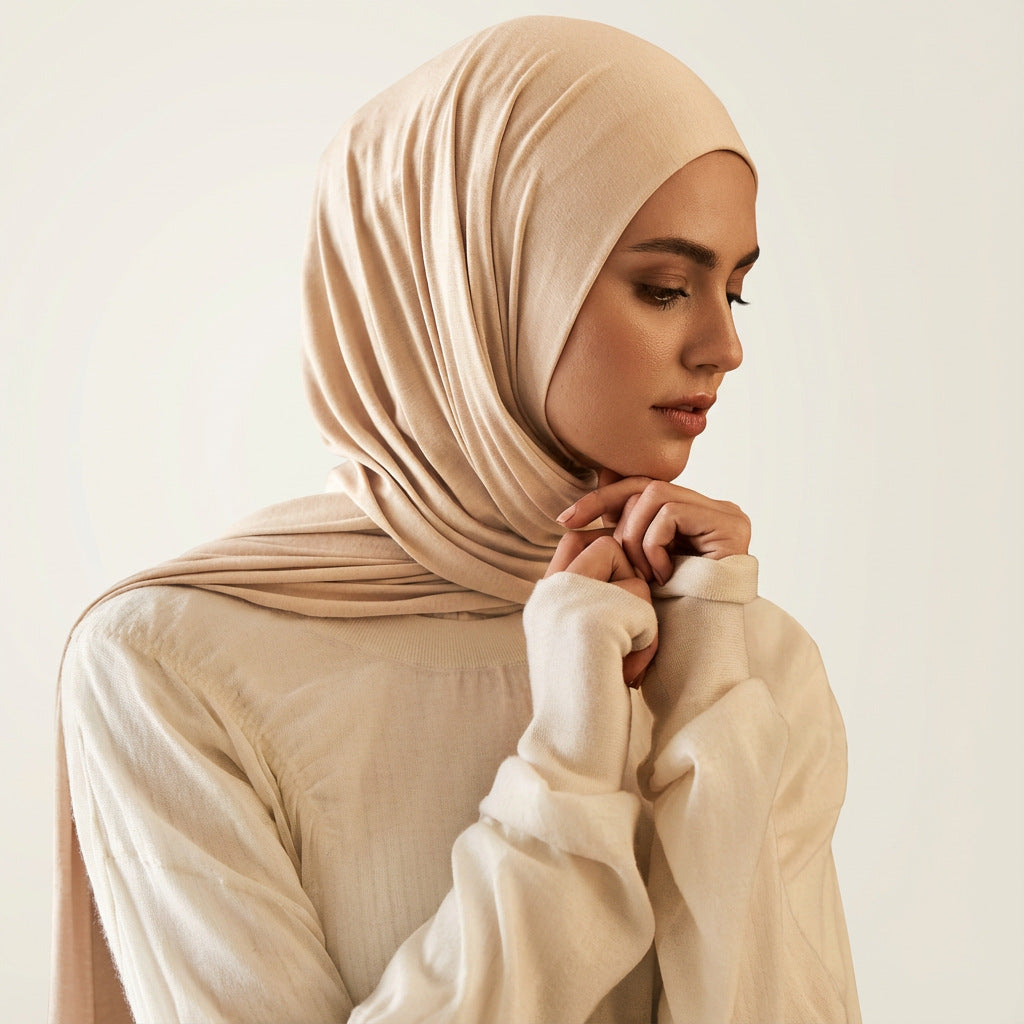 Model wearing the modal cotton headscarf wrap draped over the head and shoulders in a soft nude tone