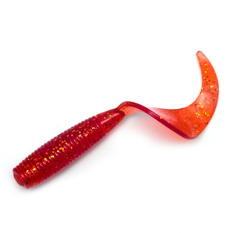 Top down view of spiral tail soft plastic fishing lures in a row