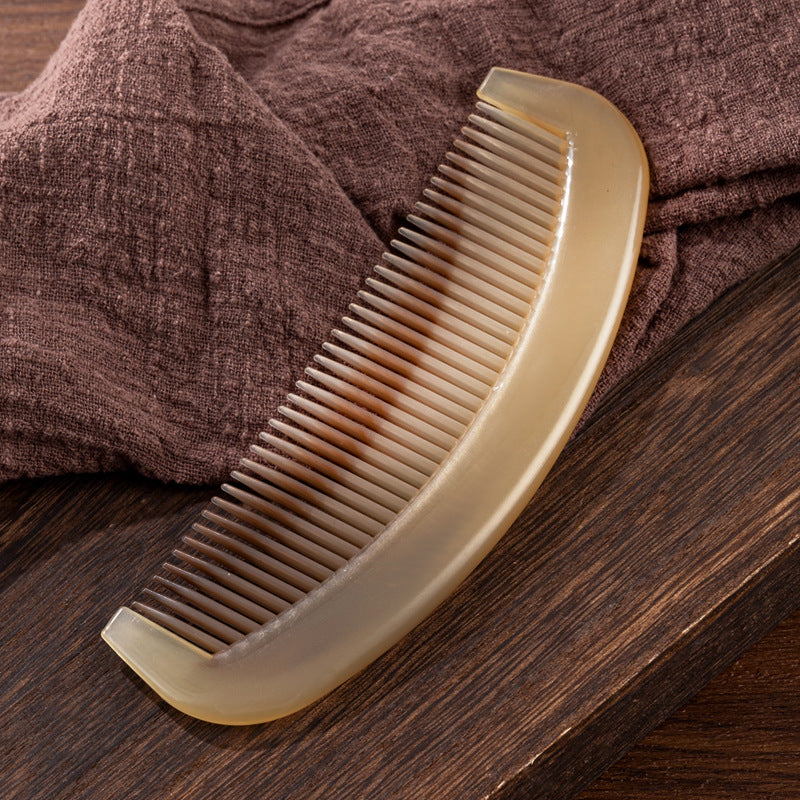 Angled view of the glossy marbled amber hair comb showing the handle and teeth