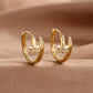 Gold zirconium nail stud earring held in hand to show its small scale