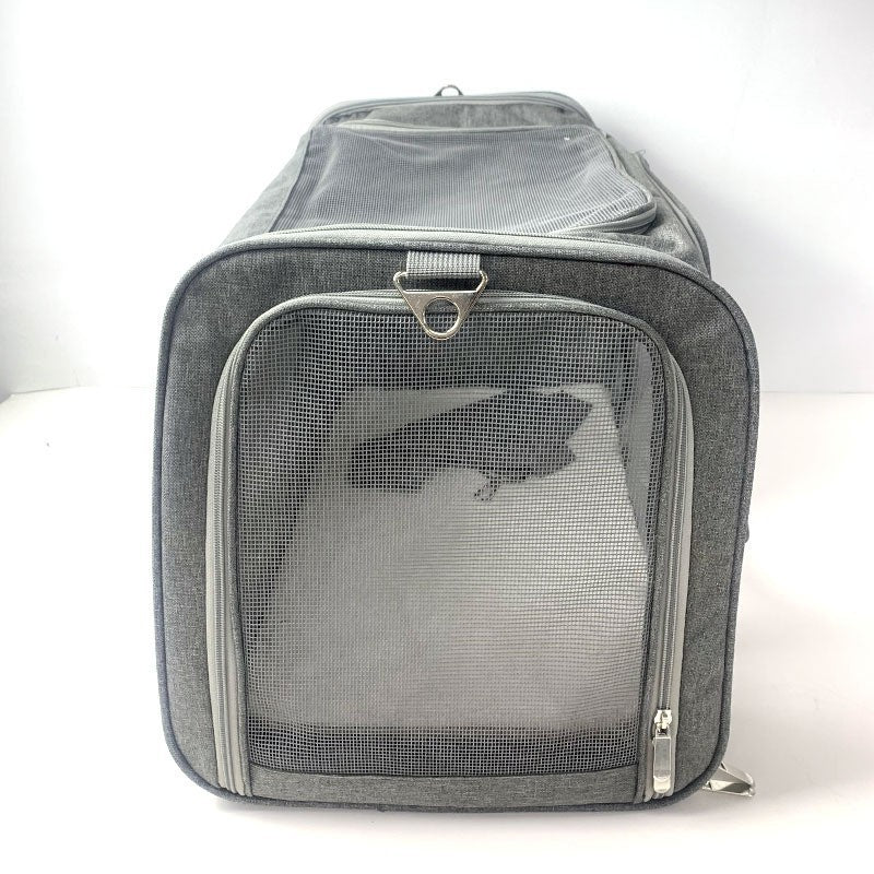 Grey pet carrier end panel in open mesh with a metal D ring on the webbing above the zip
