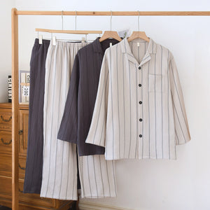 Light gray and dark gray striped cotton pajama sets hanging on a rail, shirts with chest pockets