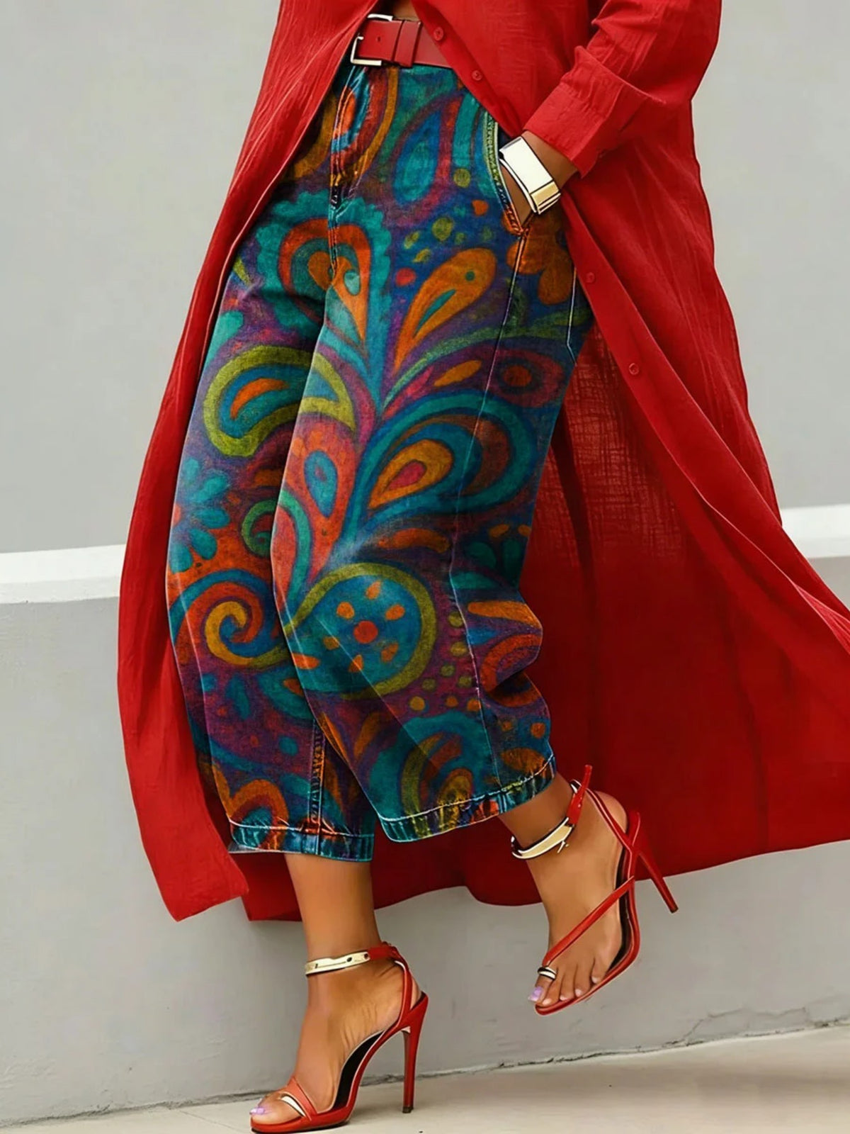 Wide leg cropped denim jeans with teal and orange paisley swirl print, red coat and heels