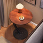 Walnut tone round C shaped side table with a pleated lamp and a cup of coffee on top, black curved arm and base