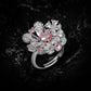 Floral cluster ring mixing pink and clear simulated stones into petal shapes, dark stone background