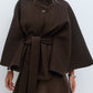 Black belted cape jacket with a stand collar, offset buttons and wide draping cape sleeves