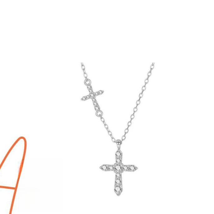 Sterling silver cross pendant necklace resting against a plain studio backdrop