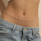 Fine gold tone waist chain with evenly spaced imitation pearl beads, worn above pale denim