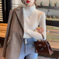 Woman wearing a slim ribbed semi high mock neck knit sweater as a fitted base layer