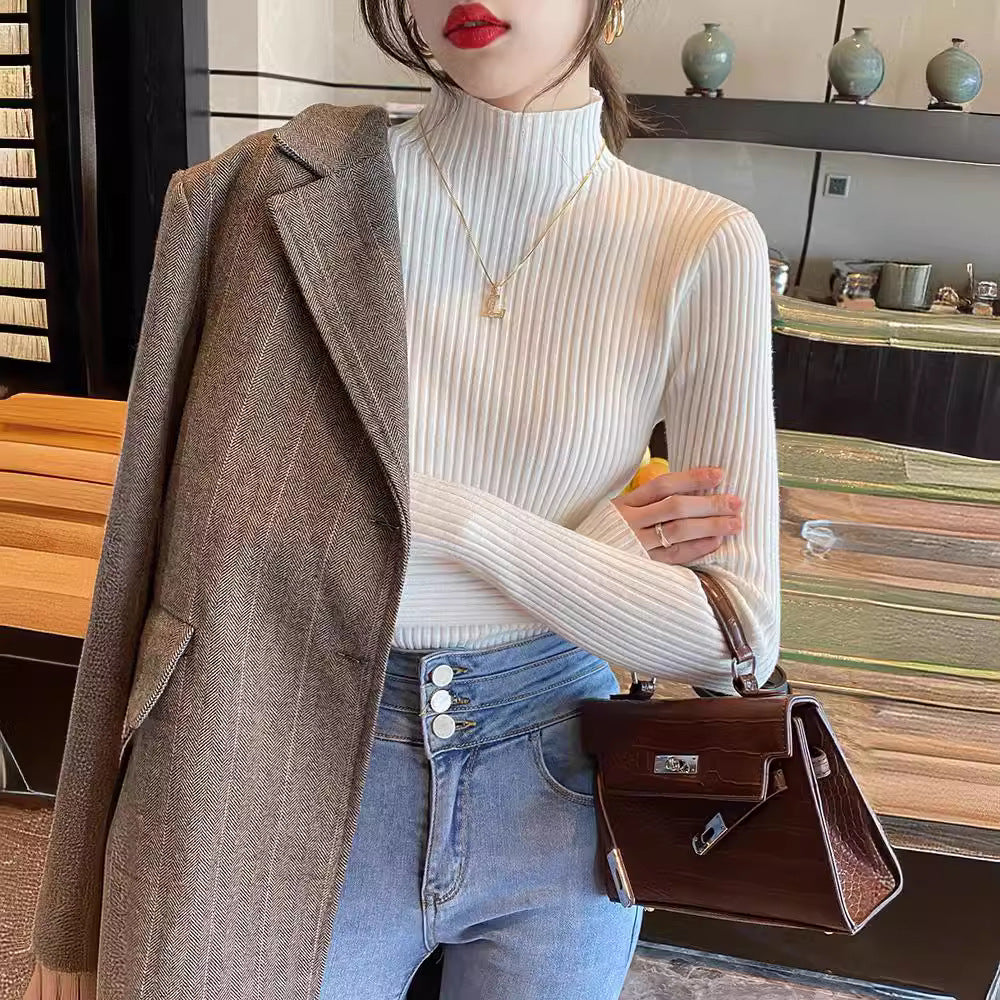 Woman wearing a slim ribbed semi high mock neck knit sweater as a fitted base layer