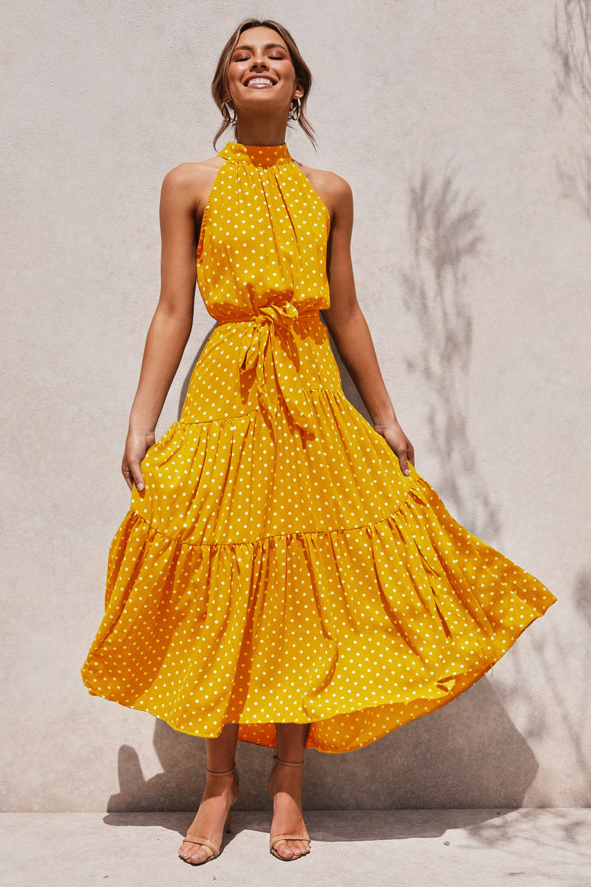 Yellow polka dot halter neck sleeveless tiered swing maxi dress worn by a model
