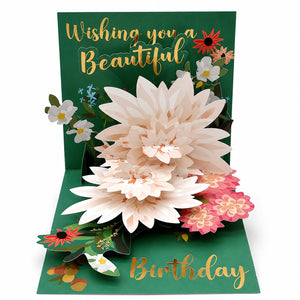 Green pop-up card open on white, cream and blush paper dahlias standing over gold foil Birthday script