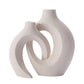 Curved hollow ceramic vase holding dried stems on a console