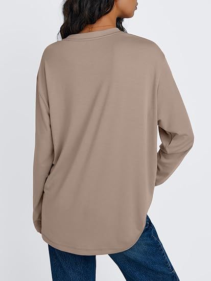 Back view of a khaki long sleeve rayon top with a rounded hem worn with blue jeans