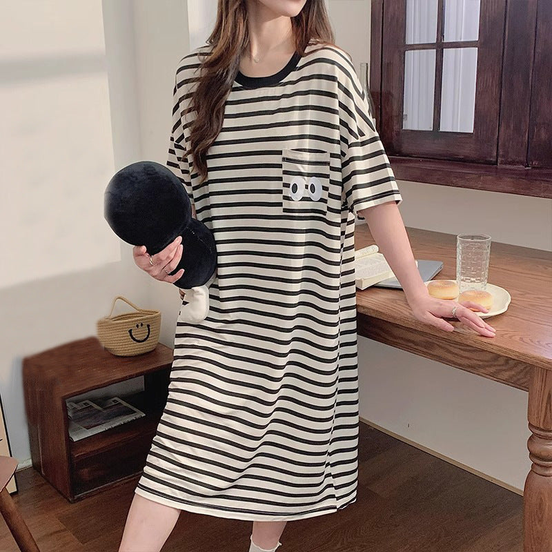 Woman holding a black plush in a black and cream striped short sleeve nightgown with a dark collar, view 1 of 7