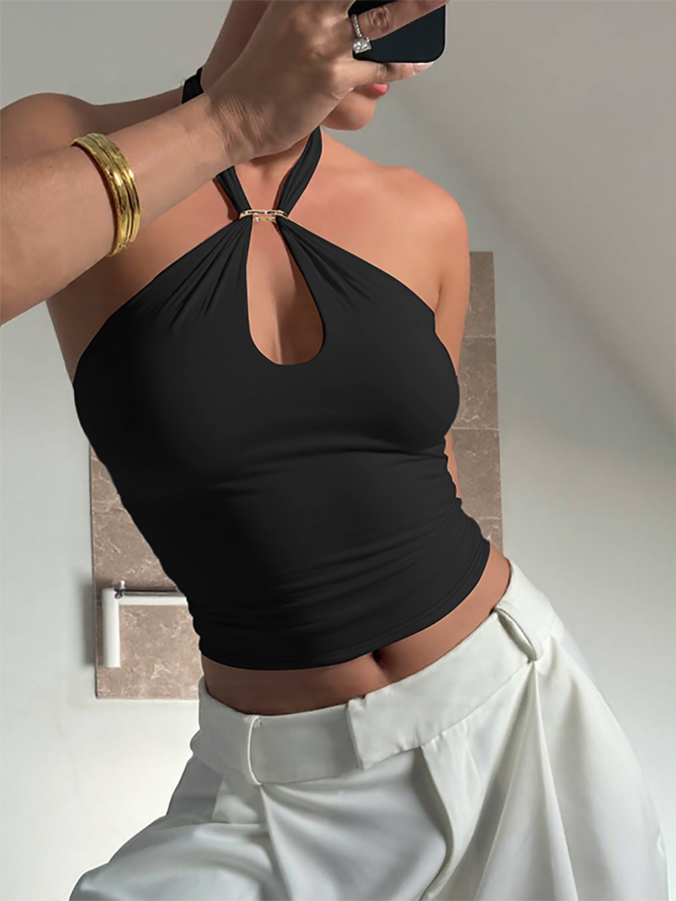 Black halter ring crop top worn with trousers showing the keyhole neckline and fit