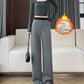 Woman in gray wide-leg pants with a black waistband and a bag, a fleece lining graphic beside her
