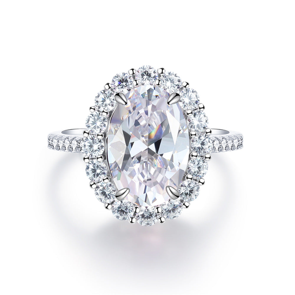 Top view of the clear stone halo ring, colourless oval centre held in four silver prongs