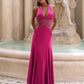 Magenta satin halter gown with sheer lace waist worn front on by a fountain